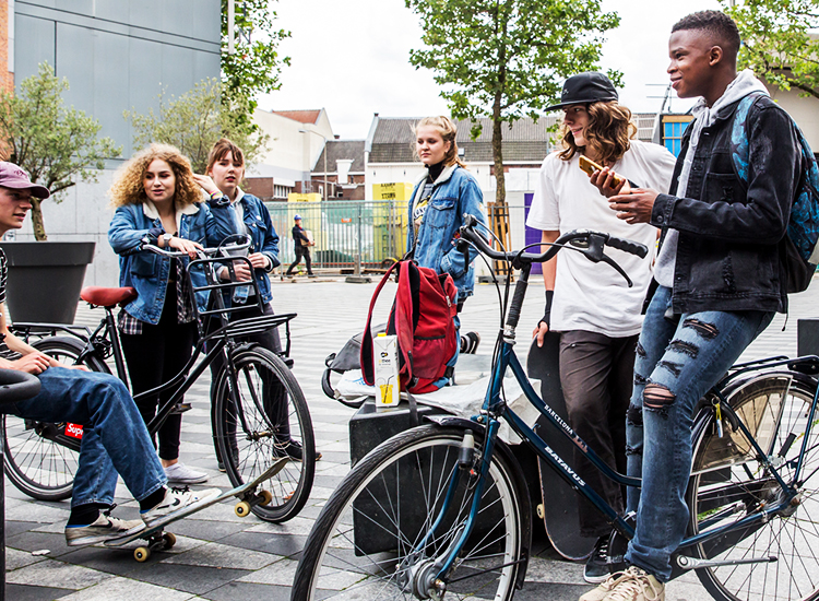 Jongeren op de fiets en zittend bij een plein