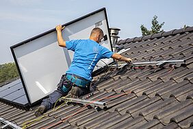 Man legt zonnepanelen op een dak 