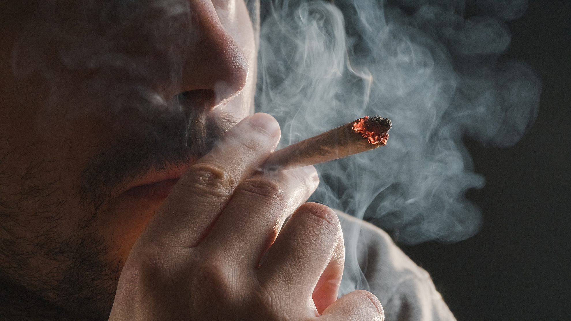 Een man rookt een joint