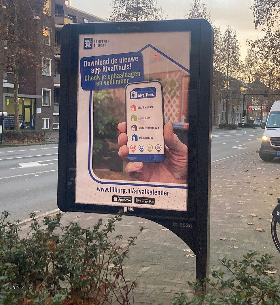 Reclamebord met daarin een poster om de AfvalThuis-app aan te kondigen. 