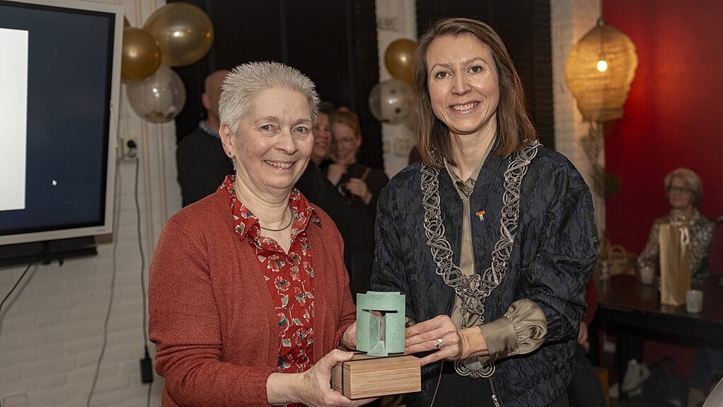 Mariëtte van Bavel en locoburgemeester Kostermans poseren lachend met de Tilburg Trofee.