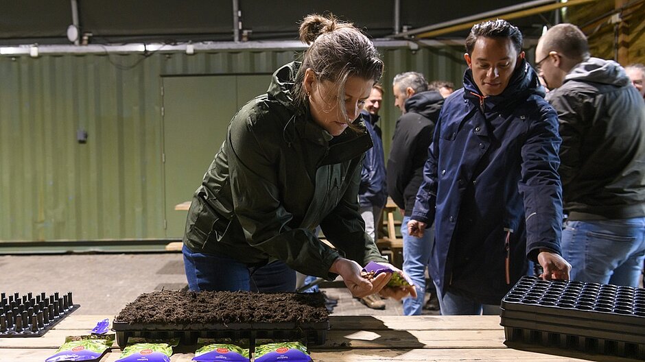 De burgemeester steekt bonen in de grond bij de Sparrenhof in het kader van NL Doet.