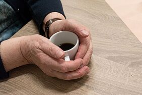 twee handen om een kop koffie