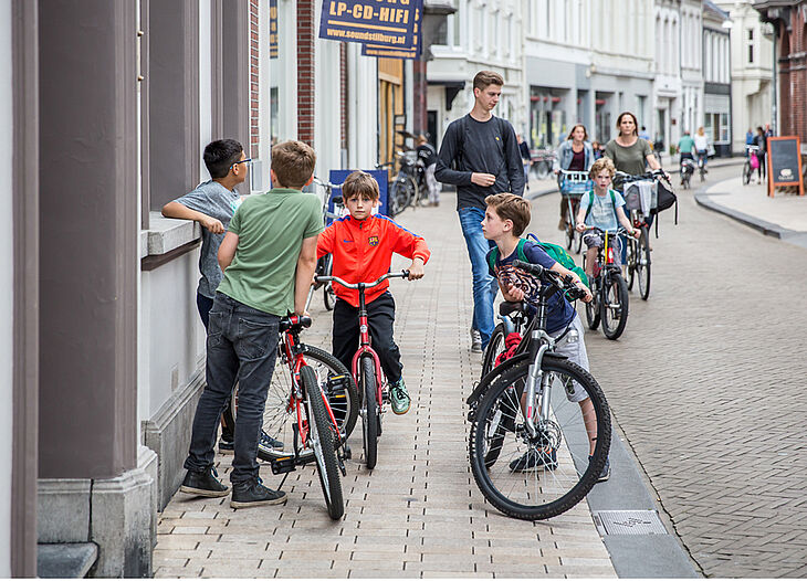Kinderen op fietsen in een straat