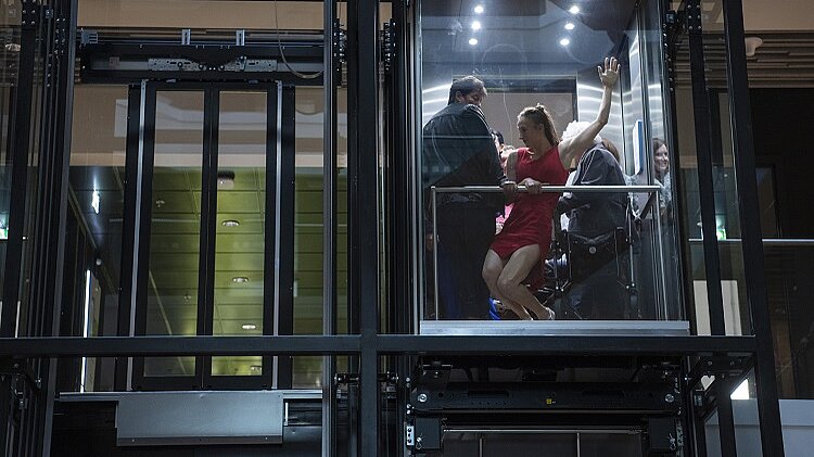 Sfeerfoto dansers in lift bij de opening van de Stadswinkel
