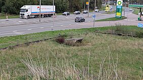 Een faunatunnel langs een autoweg met op de achtergrond een vrachtwagen en andere auto's