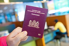 Paspoort in hand, op de achtergrond de balie