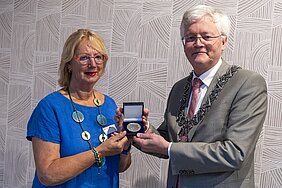 Erepenning van de gemeente voor mevrouw van Berkel, uitgereikt door burgemeester Weterings