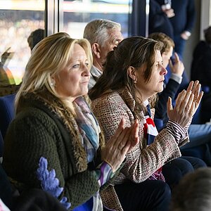 De burgemeester op de tribune en fanatiek aan het kijken naar een boeiende wedstrijd.