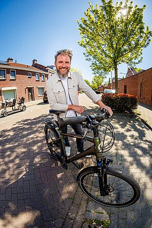 man steunt lachend op zijn fiets