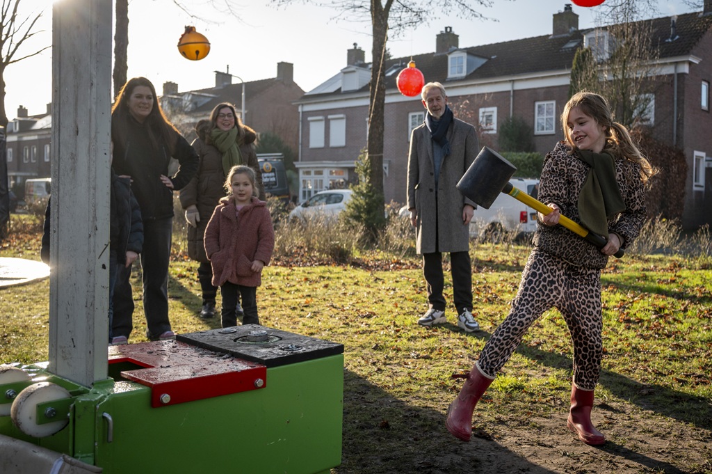 Meisje slaat op een kop van jut tijdens een van de activiteiten op oudjaarsdag 2025, terwijl een aantal mensen toekijken.