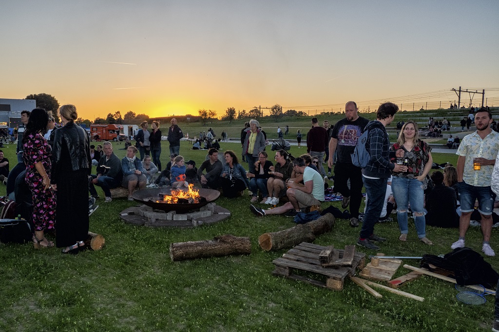 Evenement in het spoorpark: mensen in de avond bij een kampvuur