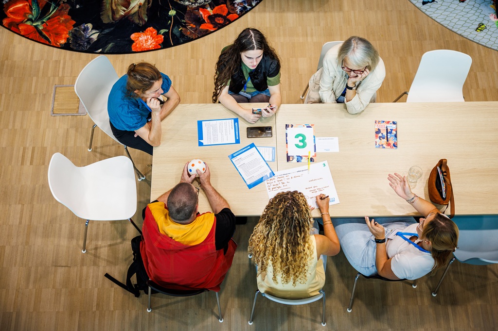 Tafel met mensen in overleg, van bovenaf gezien