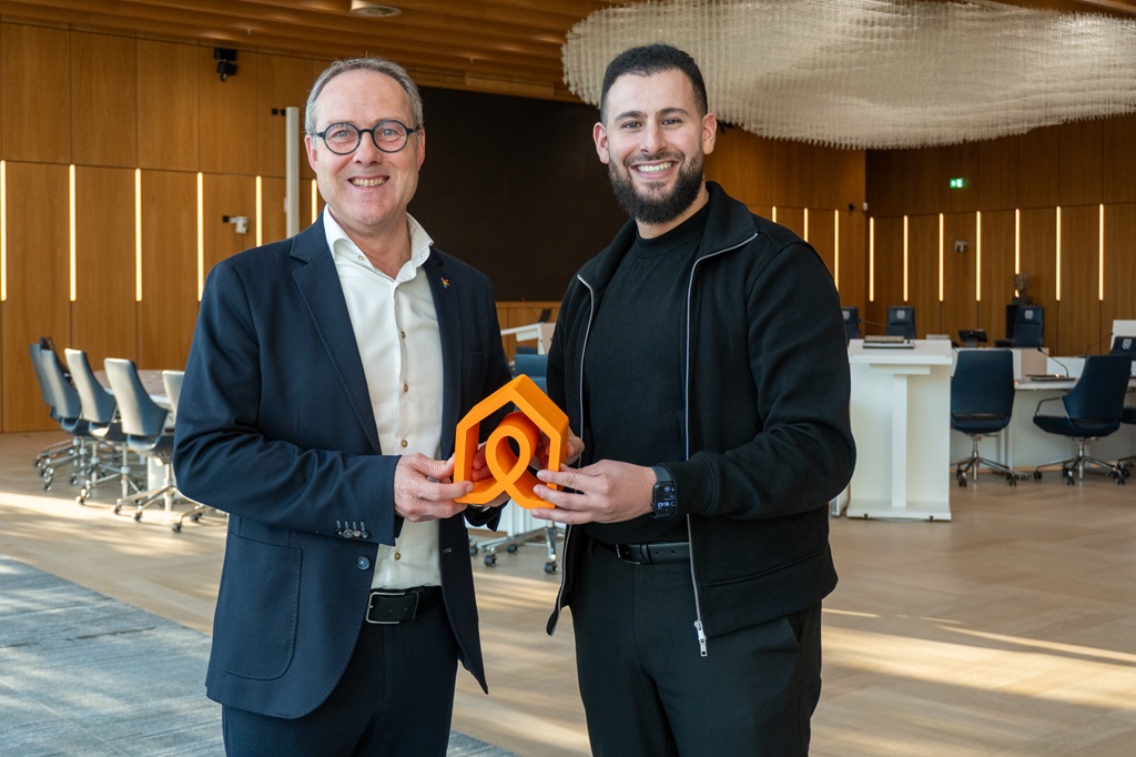 Wethouder Peter Kok samen met Nasr Ajarray van Kamers met Aandacht met een trofee in hun handen