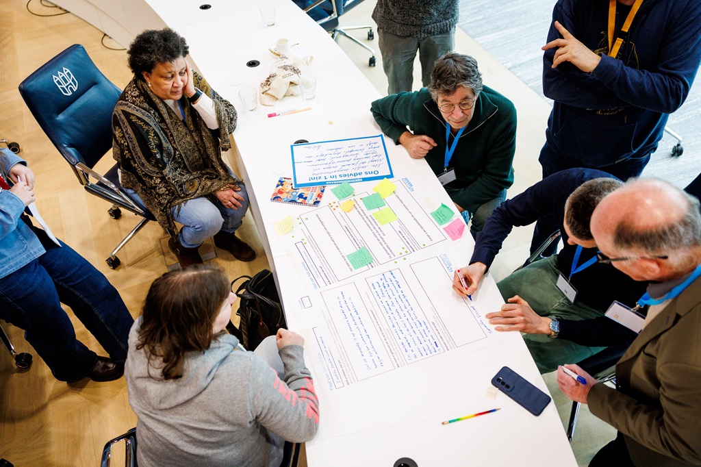 Leden van het Tilburgerberaad met elkaar in gesprek aan een ronde tafel in het Stadhuis van Tilburg.