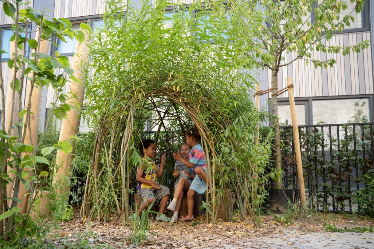 Foto van een wilgenhutje - met 3 kinderen erin