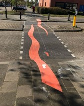 Foto van oranje zigzag-markering in straatstenen van oversteekplek